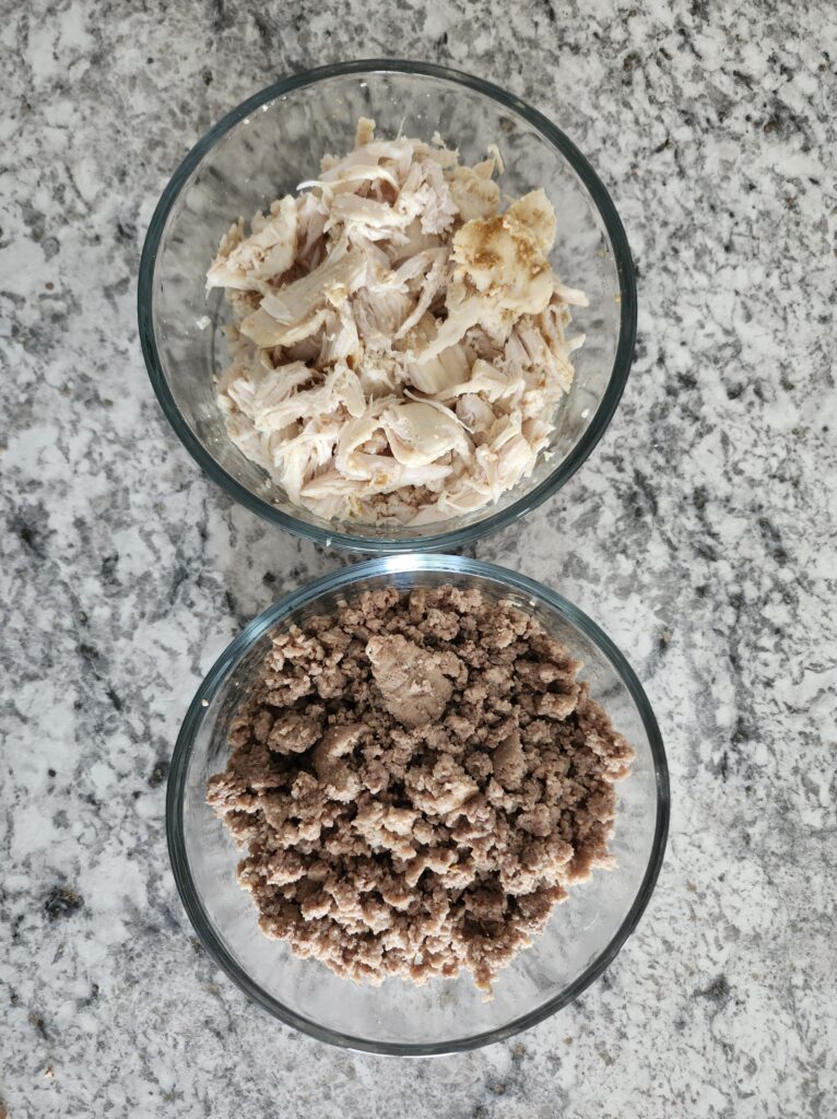 meal prepped chicken and lean beef in glass bowls