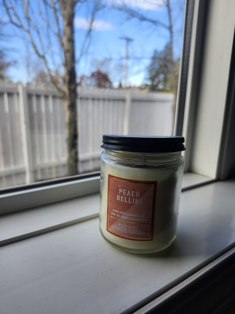 Candle with closed lid on window sill