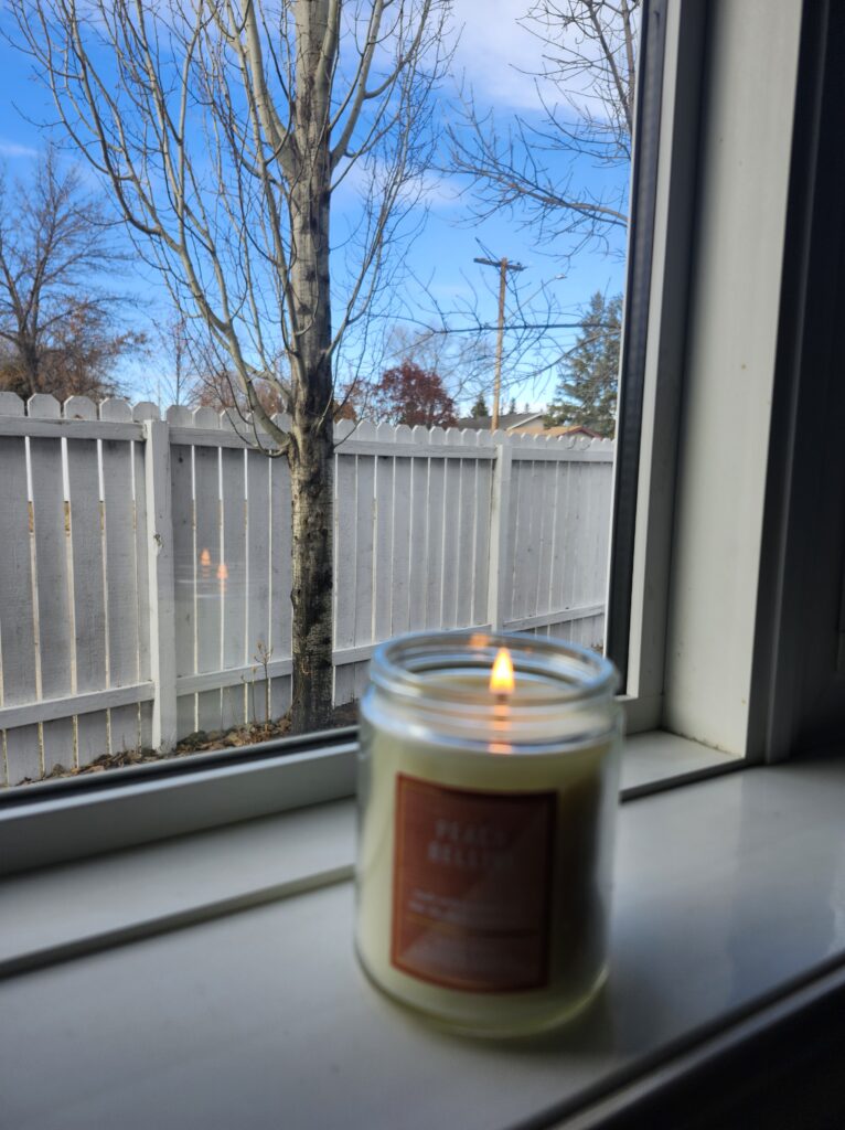 A lit candle on window sil to create peace
