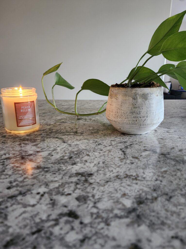 Clean counter with a plant and a candle to have a restful SUnday