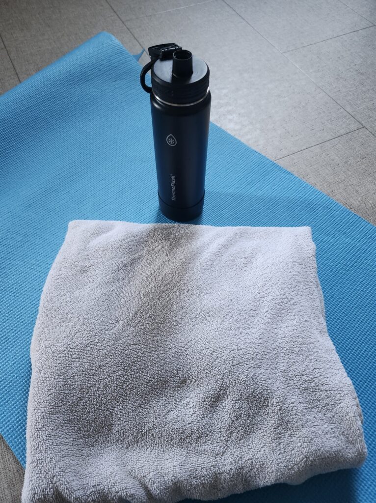 A towel and water bottle on a blue mat