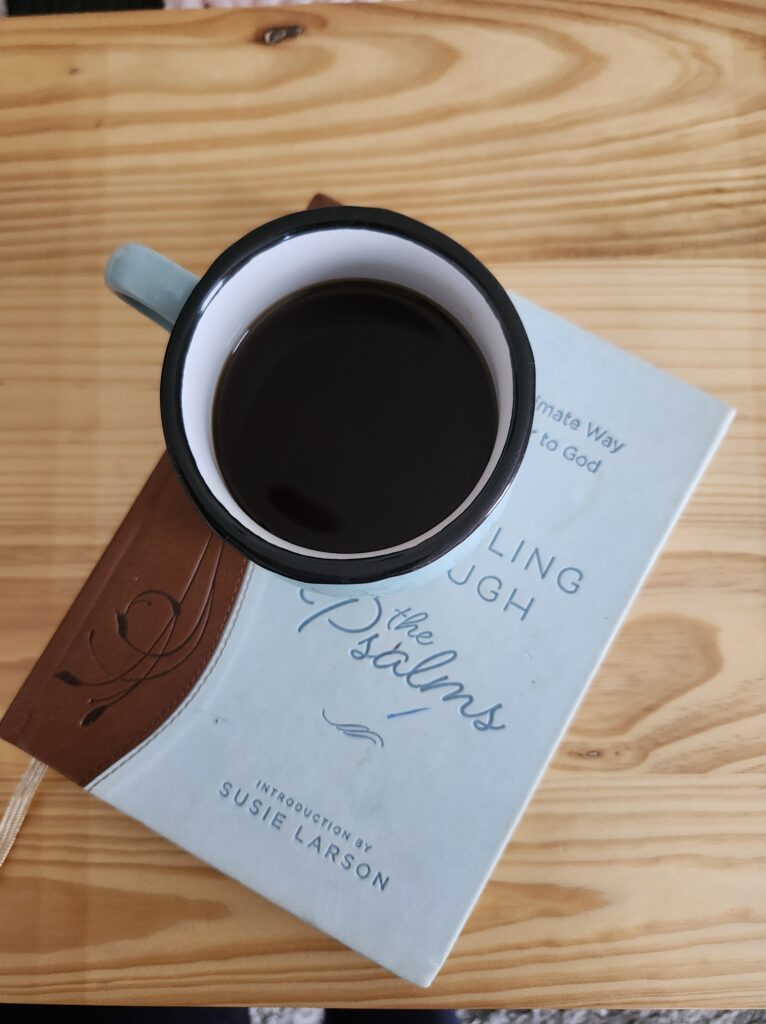Cup of coffee and book on a wooden table – a peaceful reminder to rest and recharge on recovery days