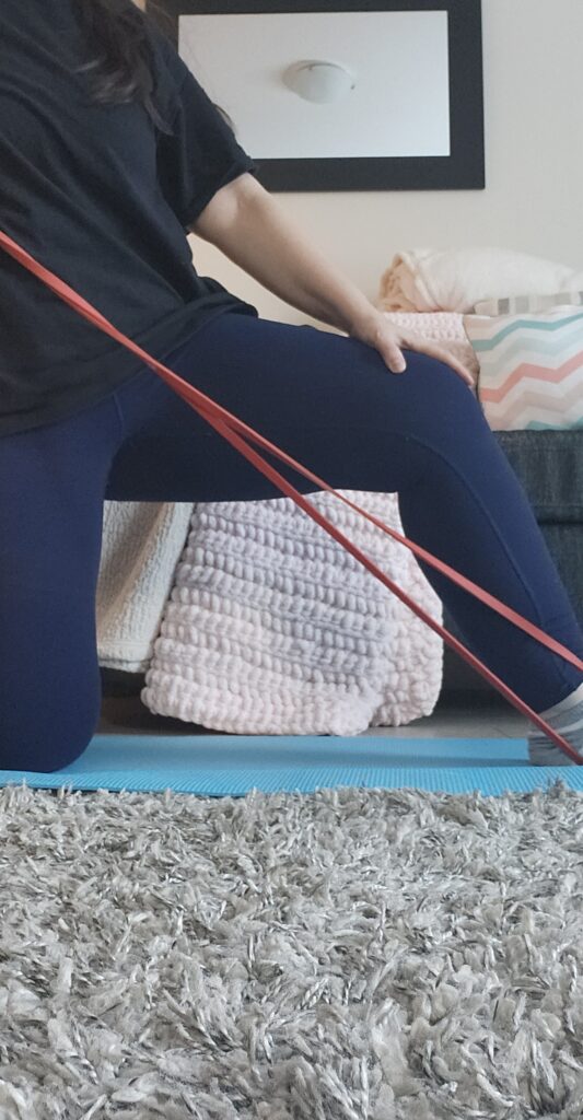 on blue mat stretching with a red band