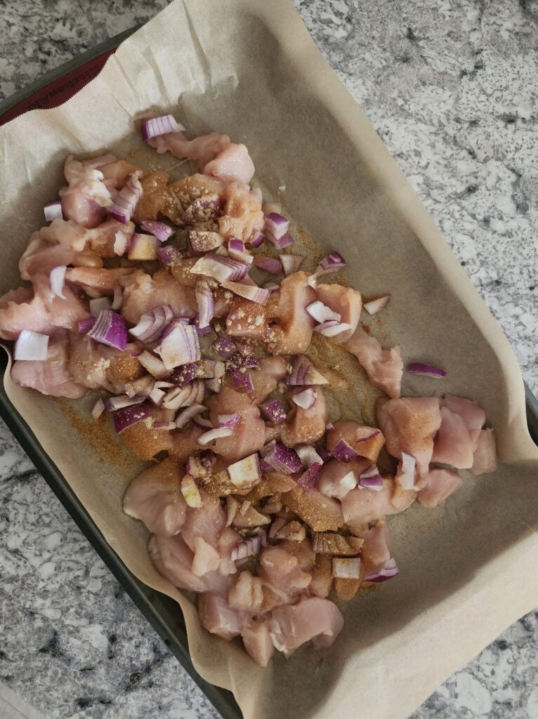 Prepping chicken breast and red onion for a quick meal prep
