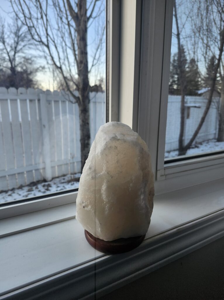 salt lamp on a window sill with soft evening light coming in
