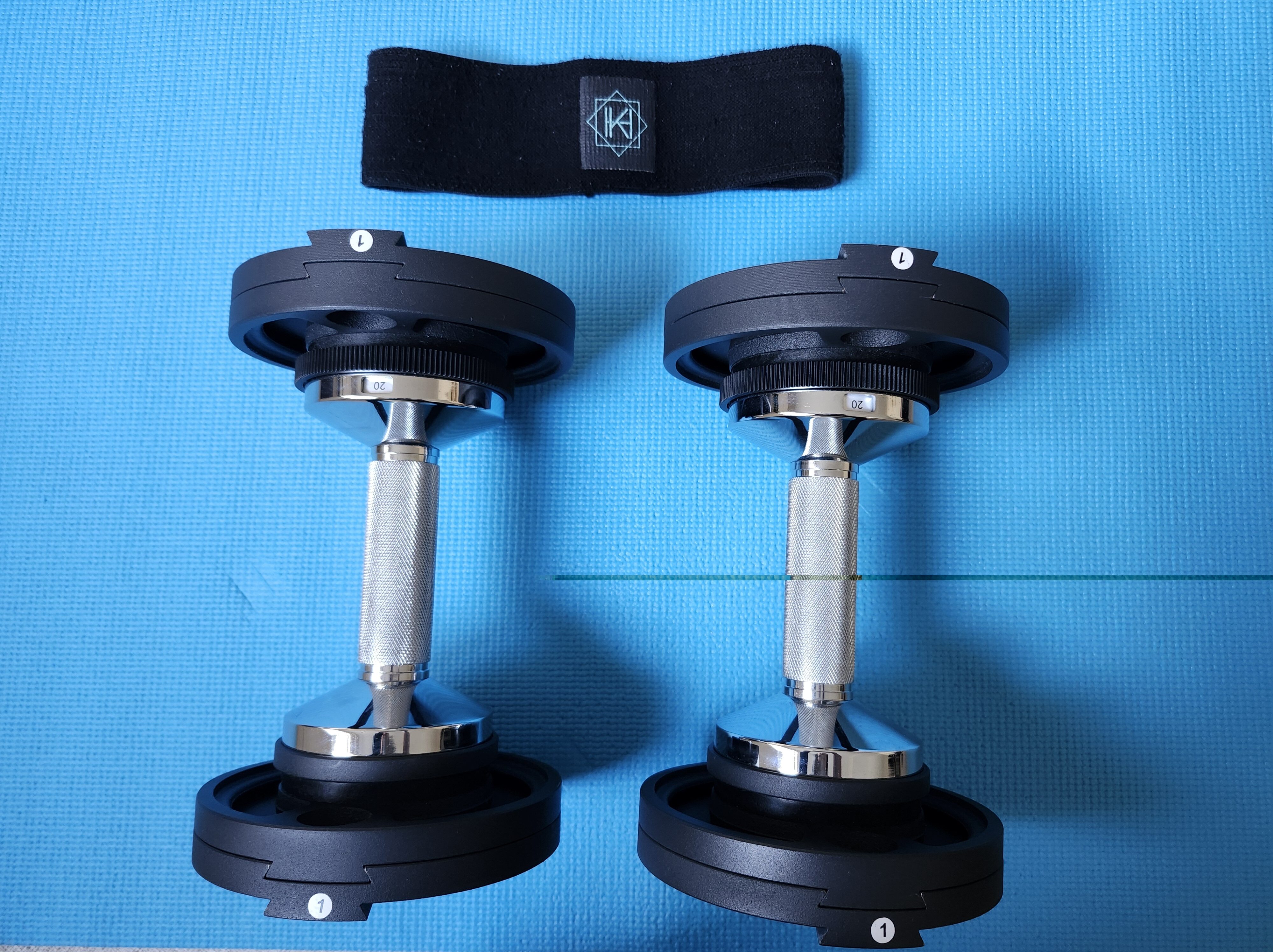 Set of adjustable free weights and a band ready for a quick workout session for busy women.