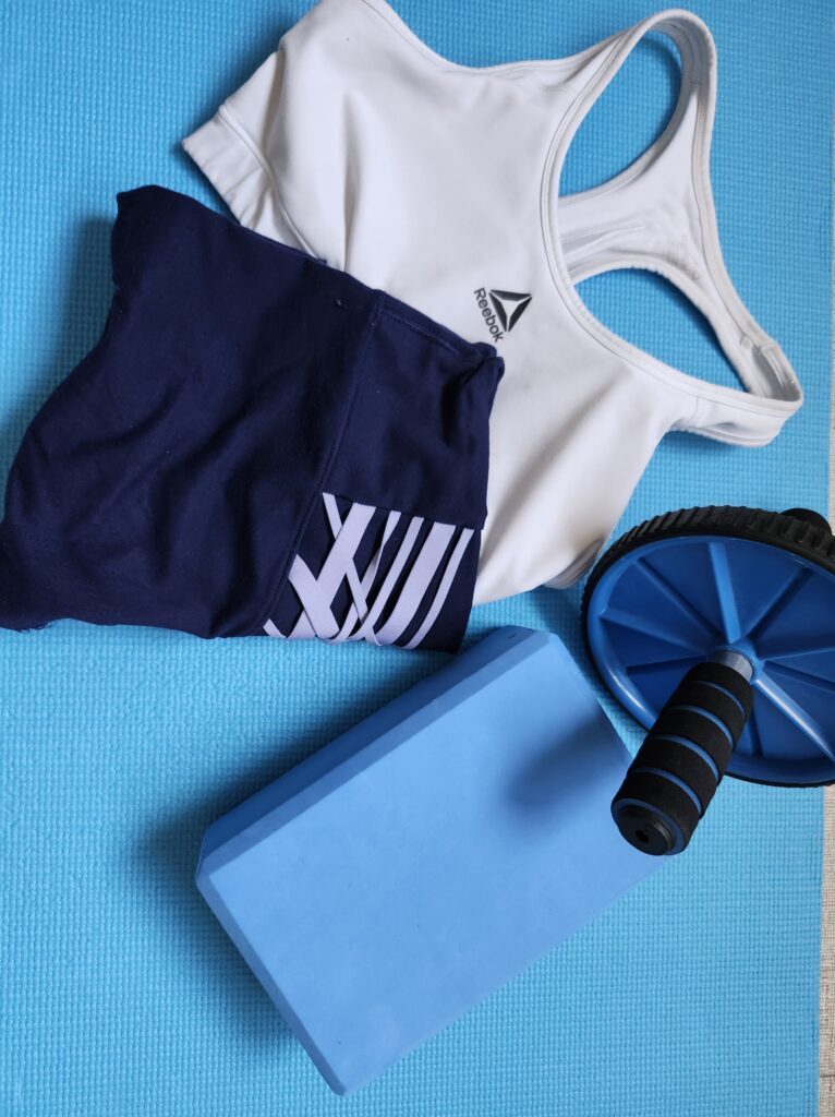 Workout clothes set out getting ready for a workout with a yoga block and ab roller